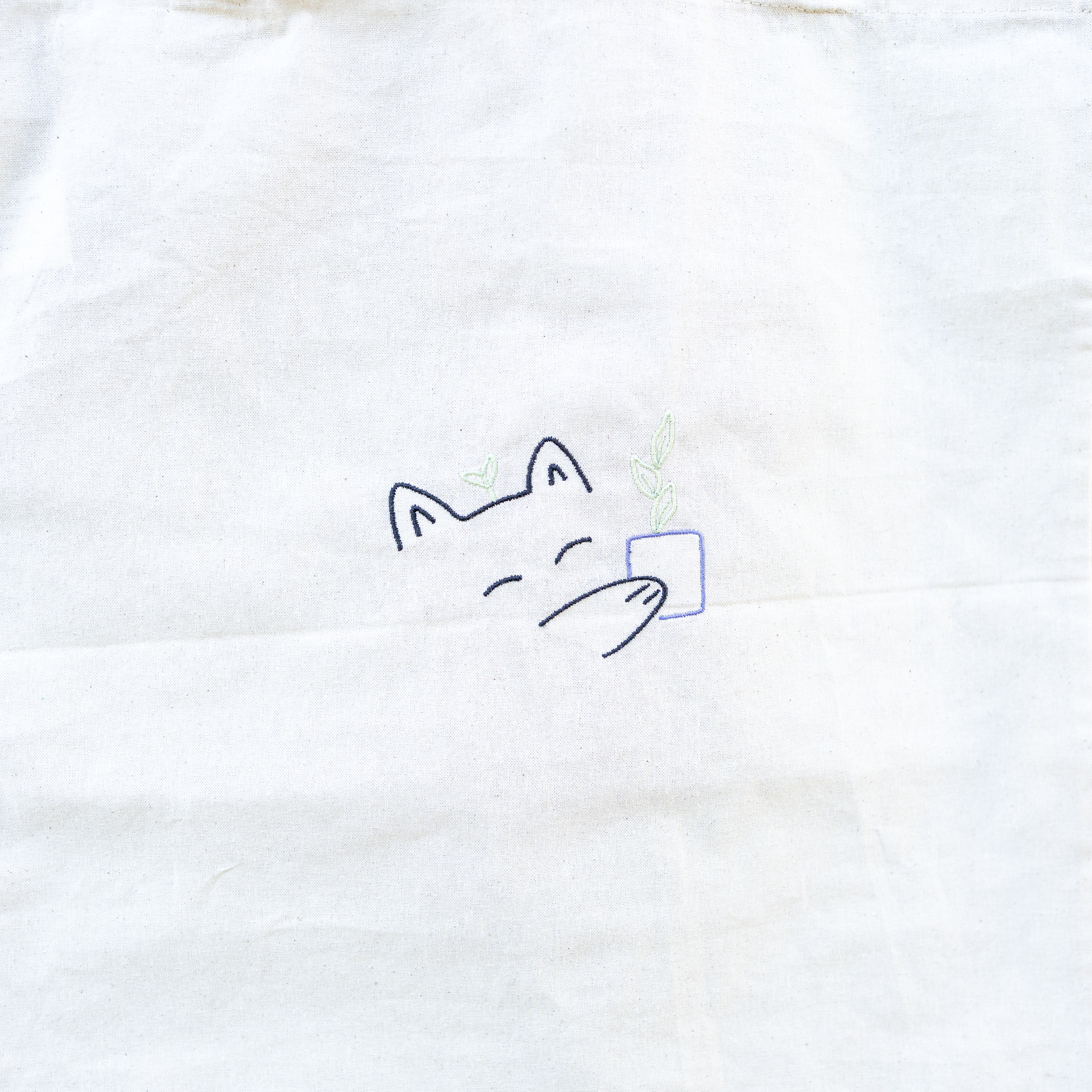 Nachhaltige Baumwoll-Tragetasche mit verspieltem Katzenmotiv und Pflanze in der Pfote